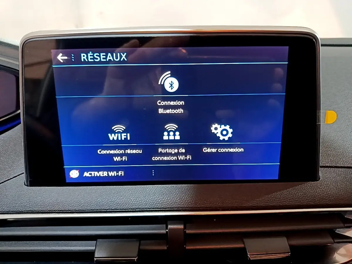 Écran tactile central du tableau de bord du Peugeot 3008 gris clair, affichant les options de connexion Wi-Fi et Bluetooth.