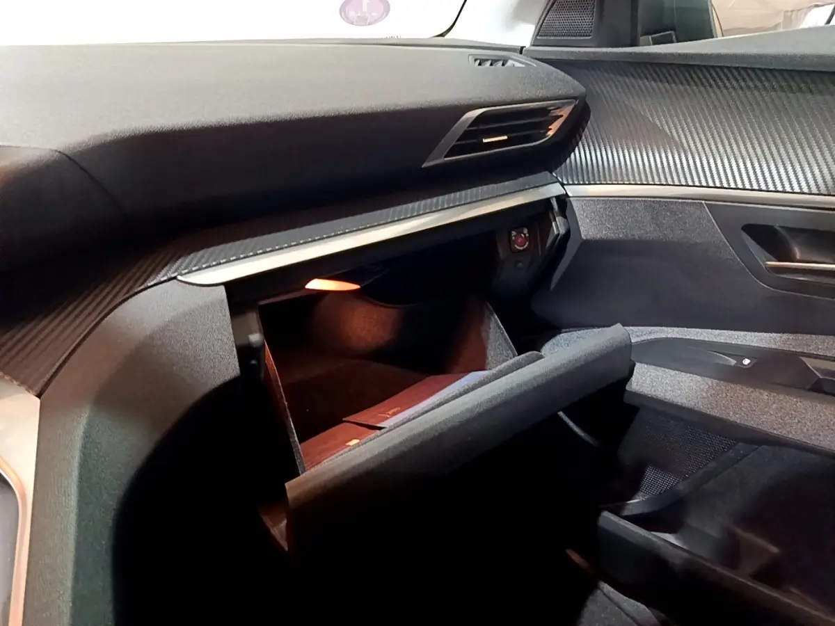 Vue intérieure côté passager du Peugeot 3008 gris clair 2020, boîte manuelle, avec boîte à gants ouverte et tableau de bord texturé.