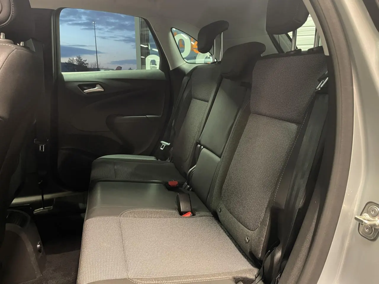 Vue intérieure côté droit de la banquette arrière en tissu gris foncé de l’Opel Crossland gris clair 2024.