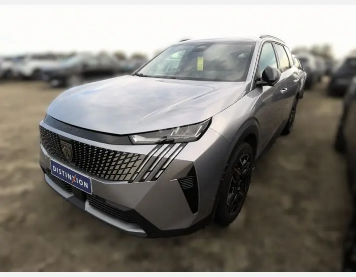 Peugeot 5008 Hybrid gris Artense en 3/4 avant droit, avec calandre distinctive et jantes noires stylées.