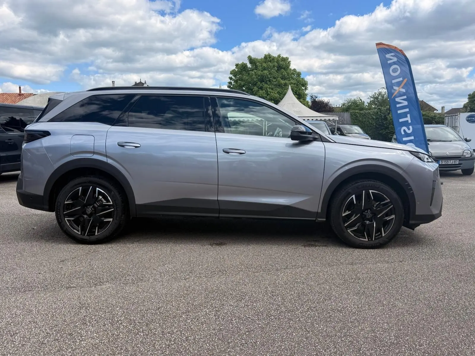 Peugeot 5008 Hybrid gris Artense vue de profil côté gauche, avec jantes noires et toit panoramique noir.