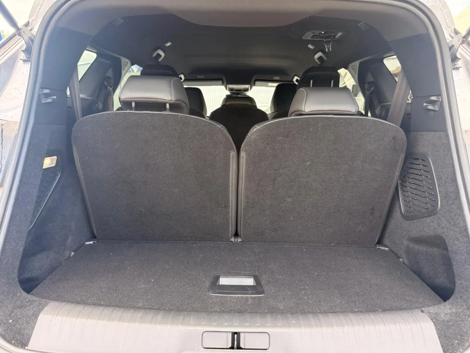 Vue arrière du coffre du Peugeot 5008 gris Artense, montrant les sièges arrière relevés et l'espace de chargement fermé.