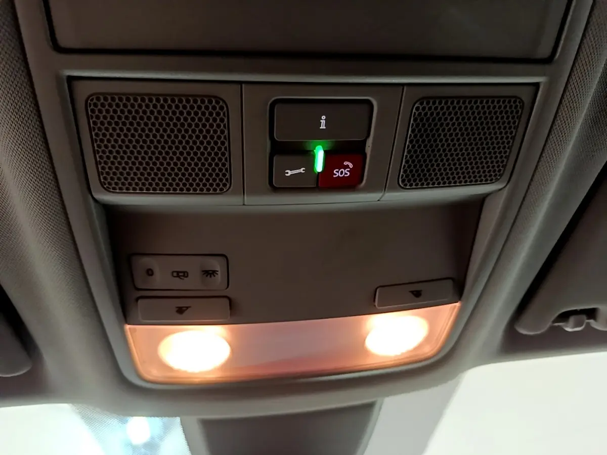 Vue intérieure du plafonnier gris clair du Skoda Karoq 2022 avec boutons d’éclairage et alerte SOS allumée.