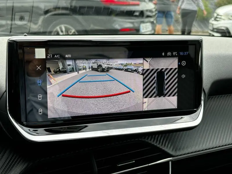 Écran tactile intérieur de la Peugeot 208 2024 affichant la caméra de recul et la vue 360° en stationnement.