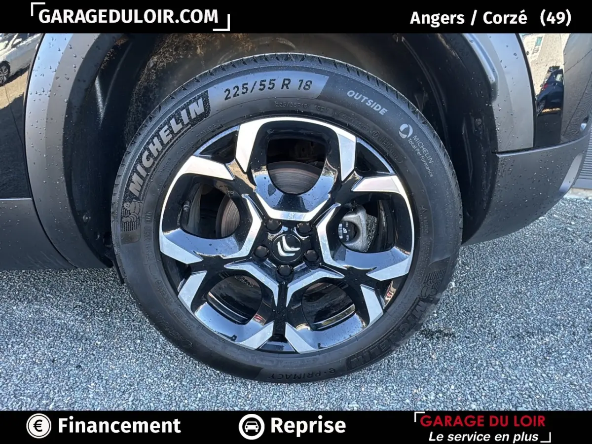 Gros plan sur la roue avant droite noire d’un Citroën C5 Aircross 2025 avec jante alliage bicolore et pneu Michelin.