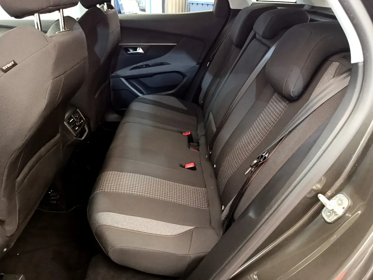 Vue côté droit sur la banquette arrière noire à motifs du Peugeot 3008 gris foncé, avec ceinture et appuie-têtes visibles.