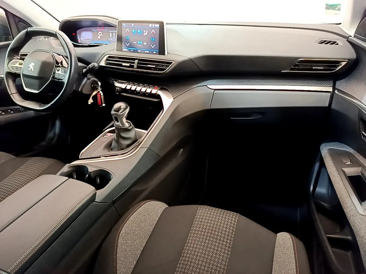 Intérieur du Peugeot 3008 Puretech 130 S&S Active 2020, vue côté passager, tableau de bord noir avec écran tactile central.