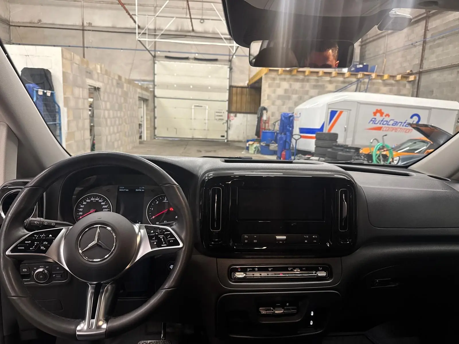 Vue intérieure du tableau de bord et volant cuir noir d'un Mercedes Vito Mixto 2025, avec écran central éteint.