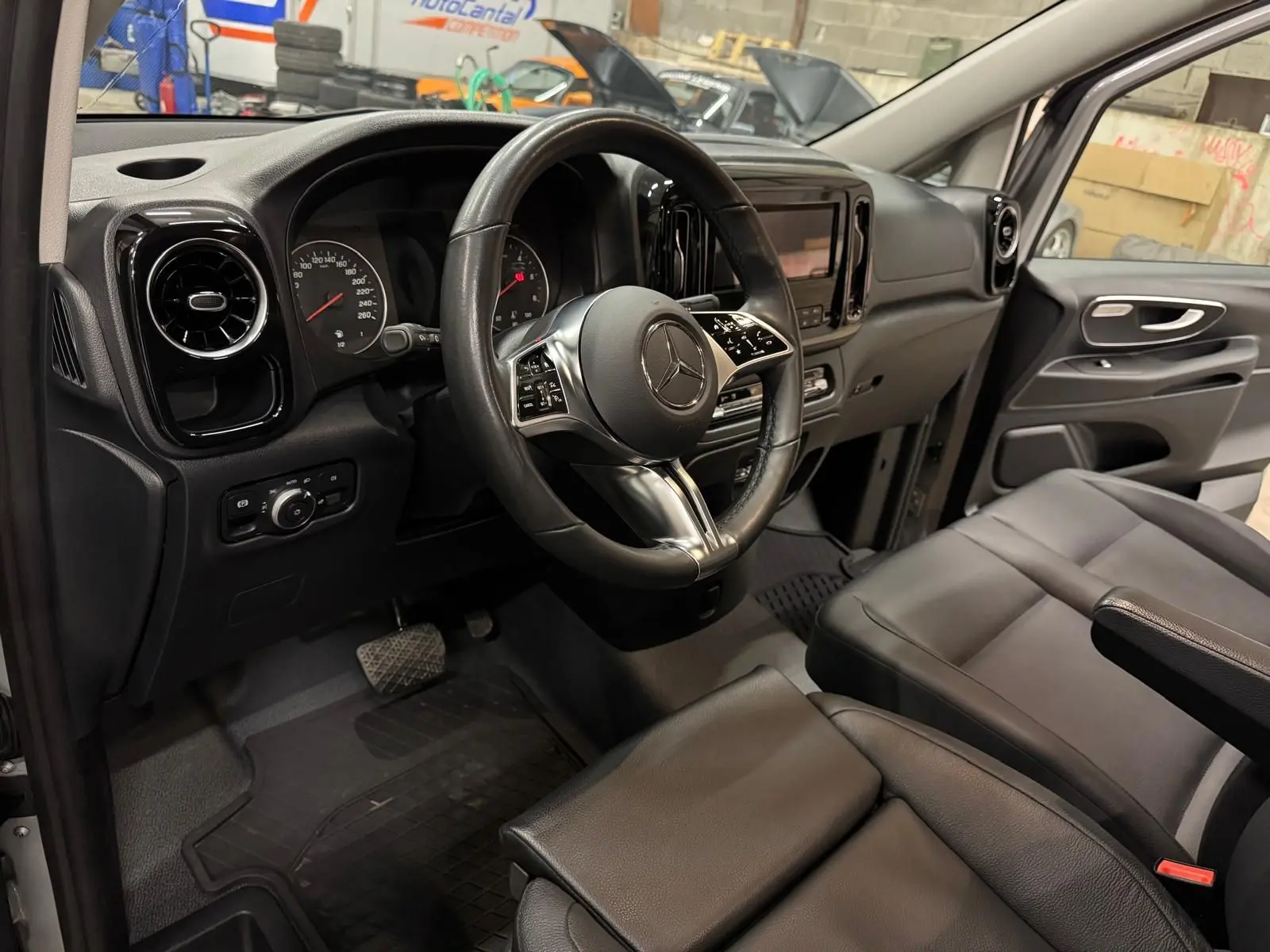 Vue intérieure côté conducteur du Mercedes Vito Mixto 2025, volant cuir, sièges noirs et tableau de bord moderne.