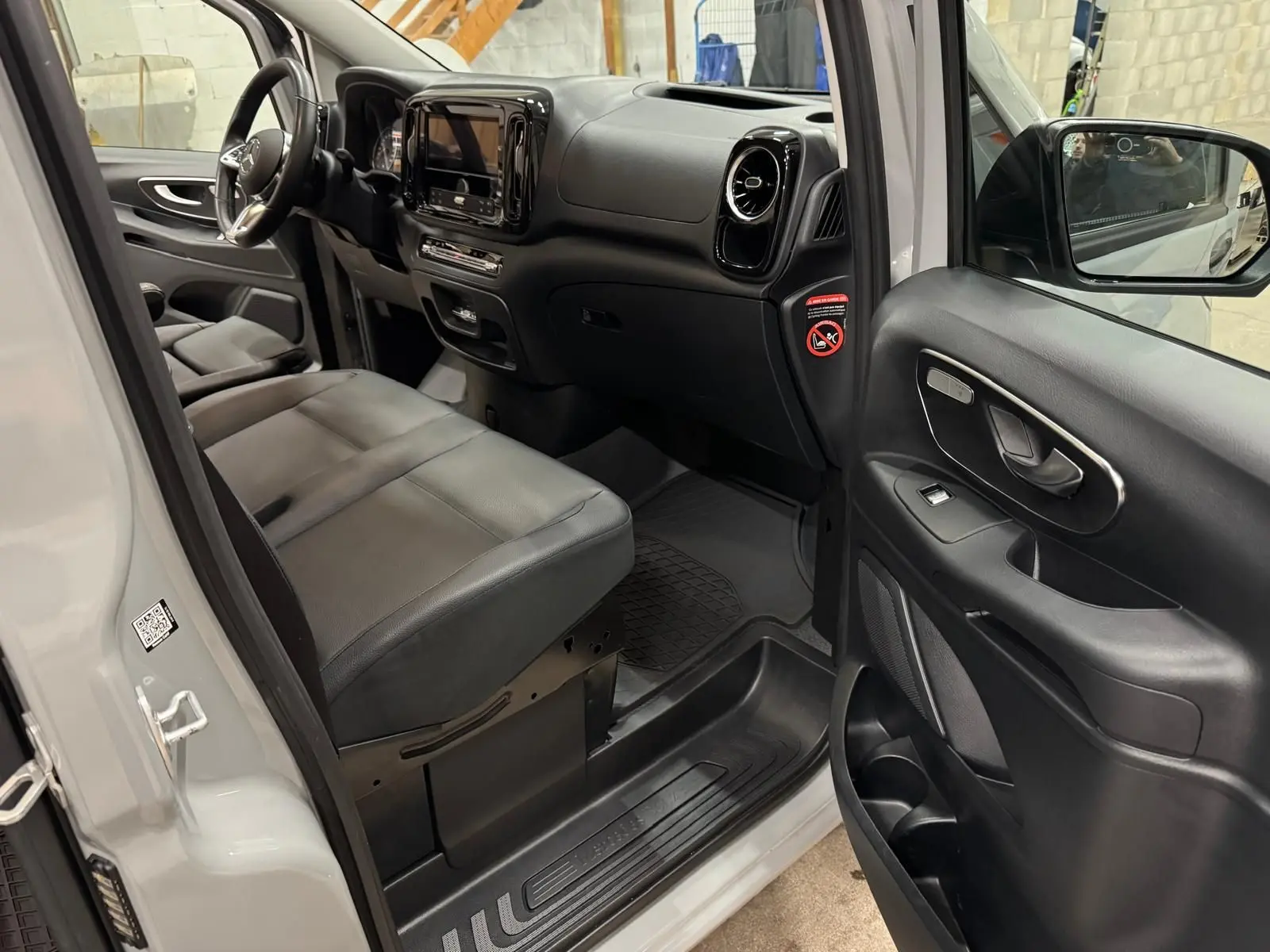 Vue intérieure côté conducteur du Mercedes Vito Mixto gris alpin, montrant sièges cuir noirs et tableau de bord moderne.