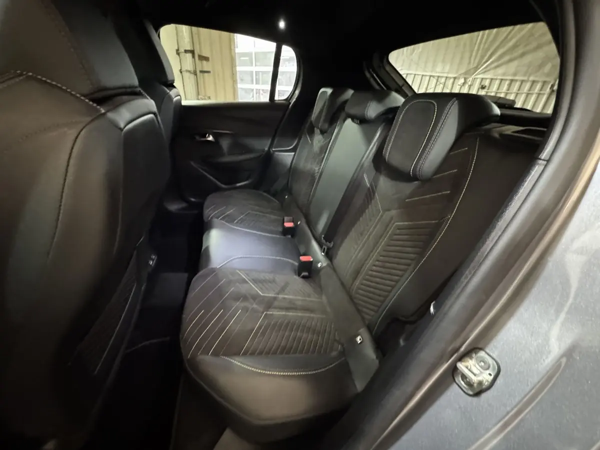 Vue intérieure arrière droite des sièges noirs avec surpiqûres jaunes de la Peugeot 208 Hybrid 136 eDCS6 GT gris clair.