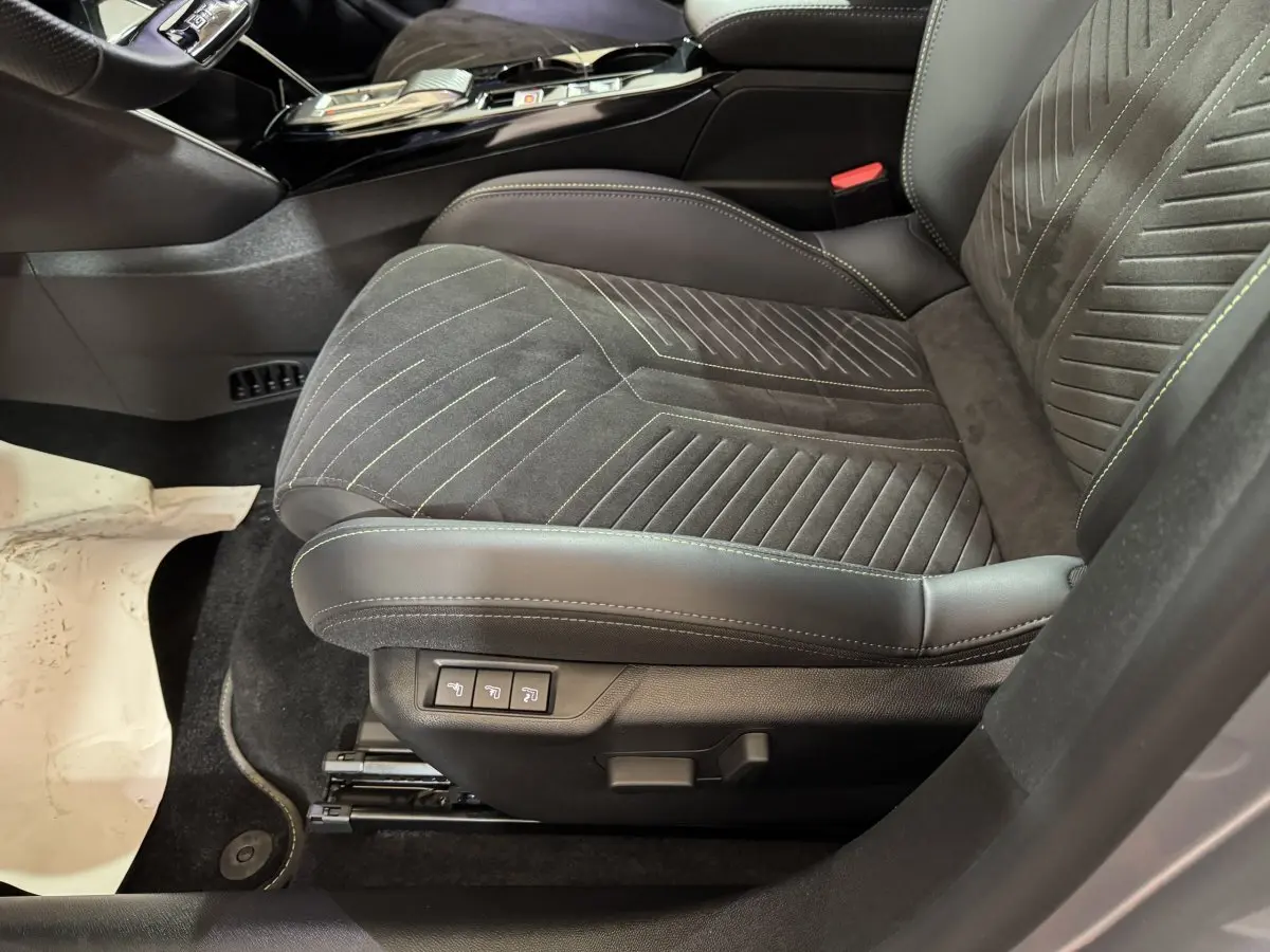 Gros plan sur le siège avant droit gris foncé en alcantara et cuir de la Peugeot 208 Hybrid 136 eDCS6 GT 2025.