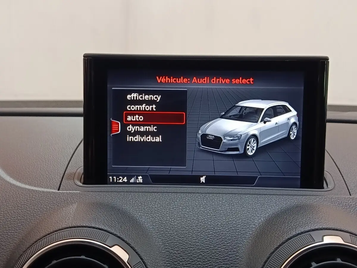 Écran central affichant la sélection de modes de conduite avec une Audi A3 blanche vue de 3/4 avant droite.