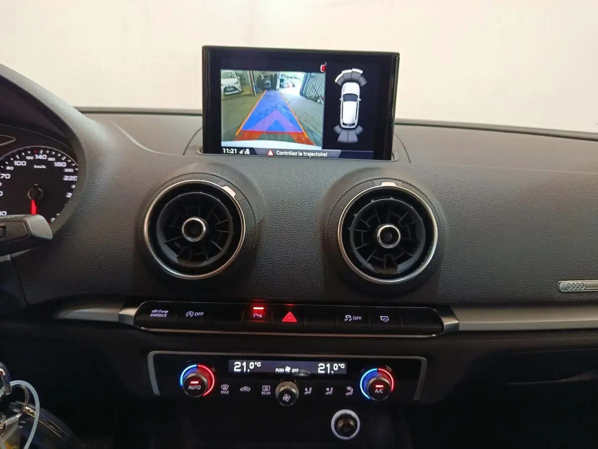 Vue intérieure du tableau de bord de l'Audi A3 blanc 2020, avec écran tactile affichant la caméra de recul.