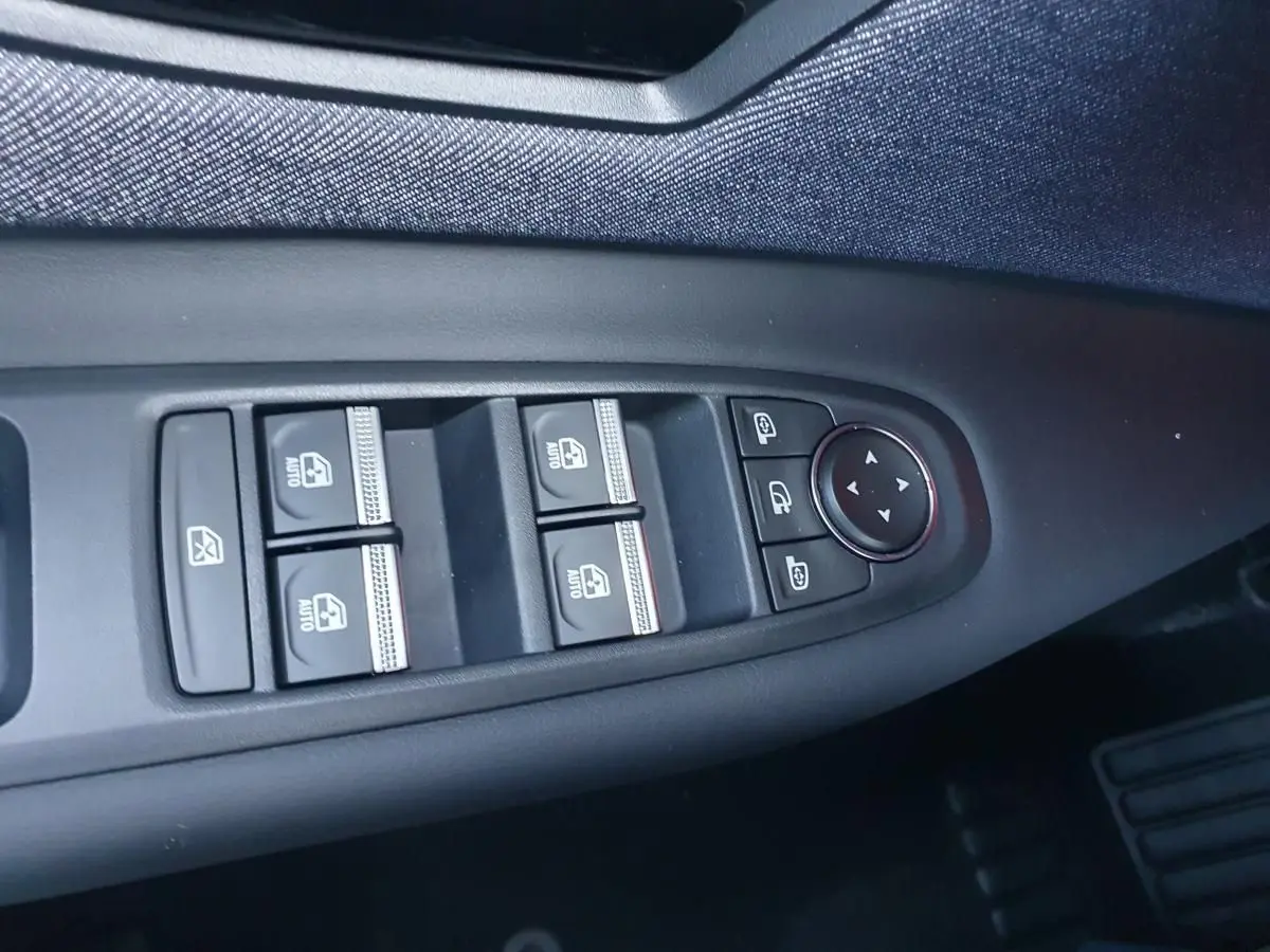 Commande des vitres électriques et réglages des rétroviseurs sur la porte côté conducteur d'une Renault R5 jaune Pop 2026.