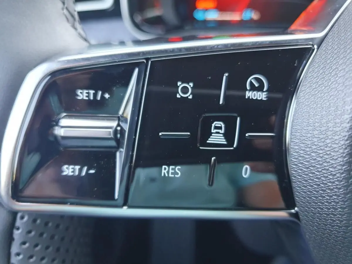Gros plan sur les commandes au volant noir brillant de la Renault R5 E-TECH jaune Pop, avec boutons de régulateur de vitesse.