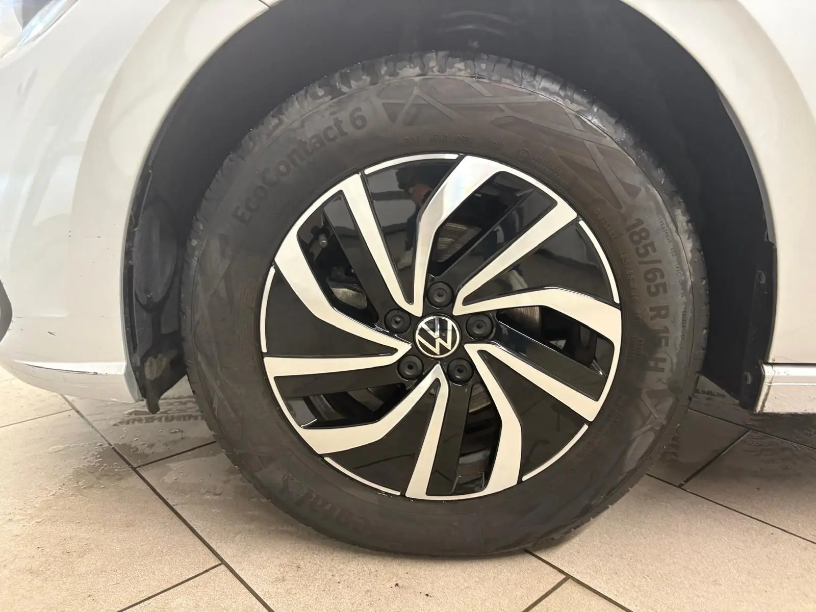 Gros plan sur la roue avant gauche d'une Volkswagen Polo 2024 argentée avec jante noire et argentée au design moderne.