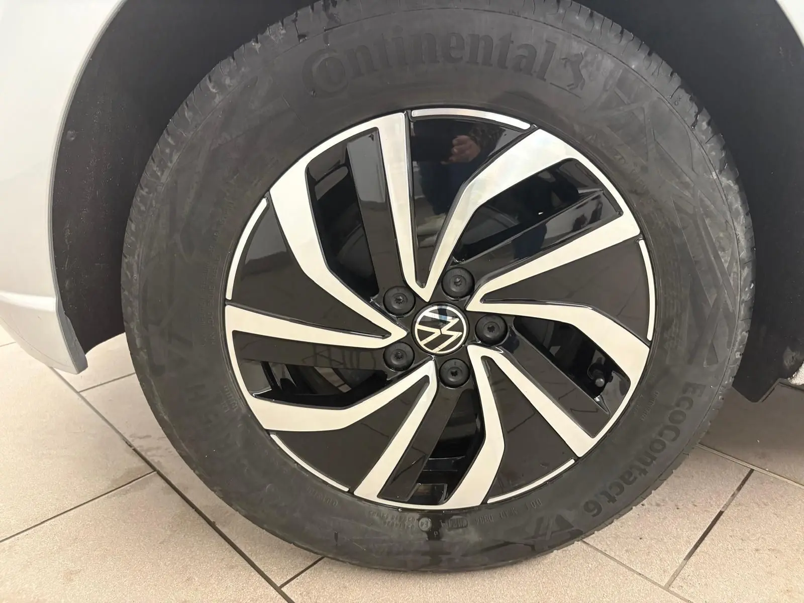 Gros plan sur la roue avant droite d'une Volkswagen Polo 2024 argentée avec jante alliage bicolore noire et argent.