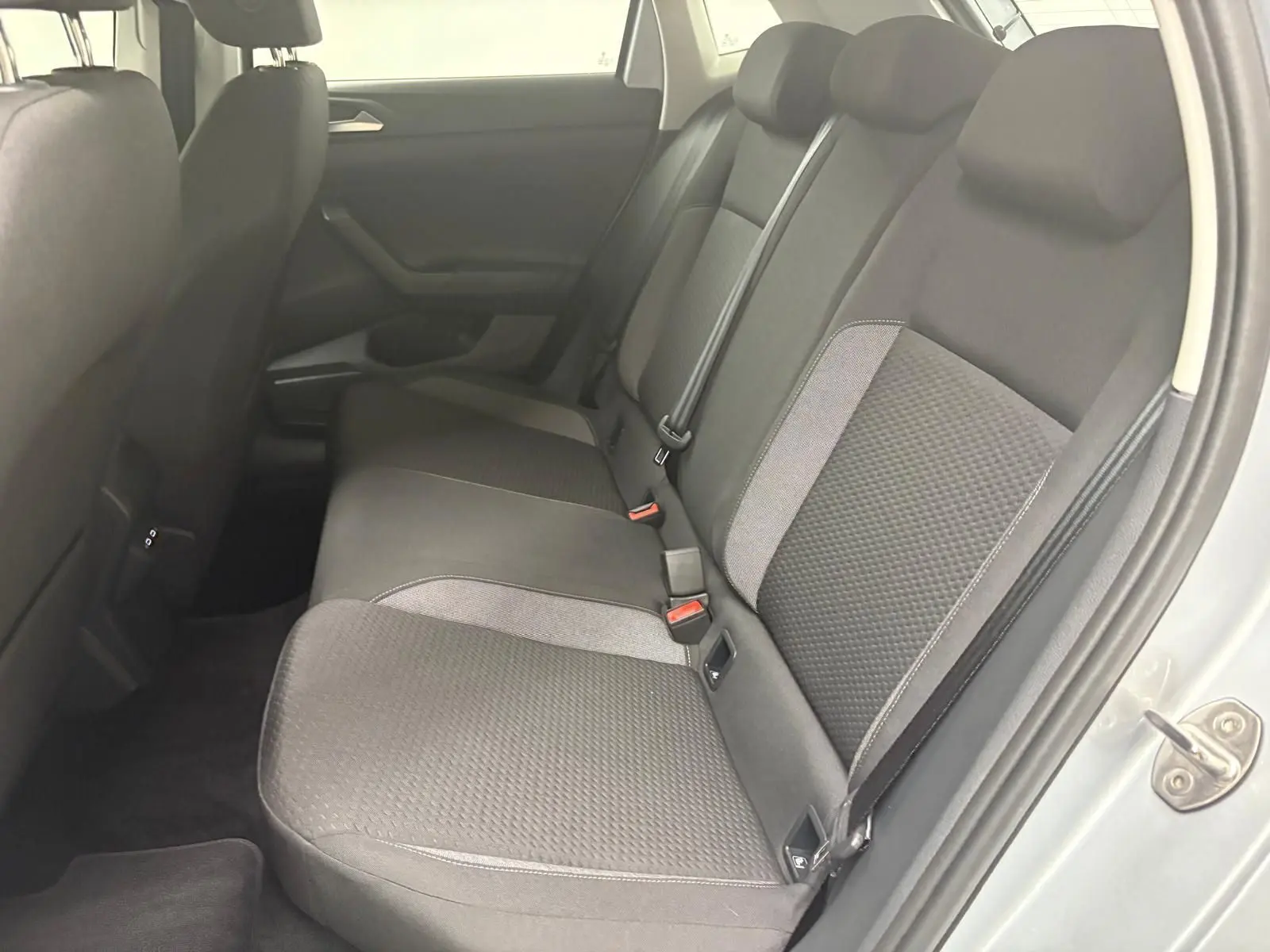 Vue intérieure côté droit des sièges arrière en tissu gris de la Volkswagen Polo 2024 Reflet d'argent.
