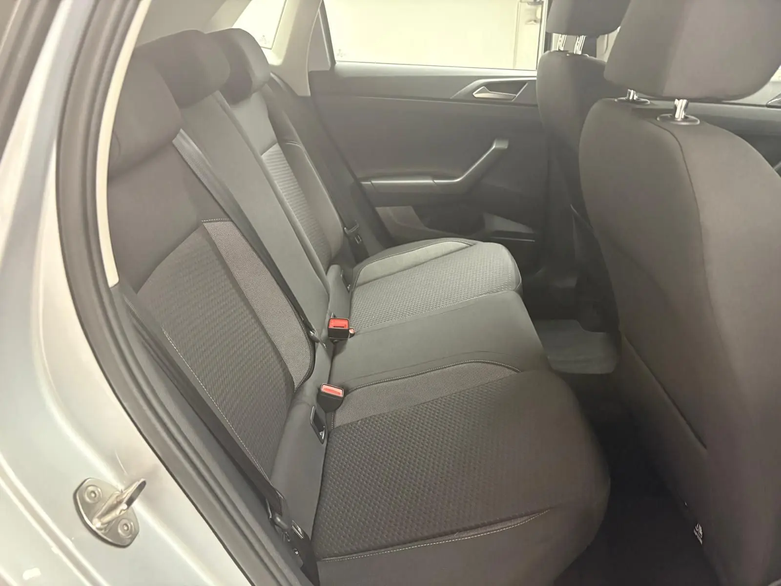 Vue intérieure côté gauche sur les sièges arrière en tissu gris d'une Volkswagen Polo 2024 Reflet d'Argent.
