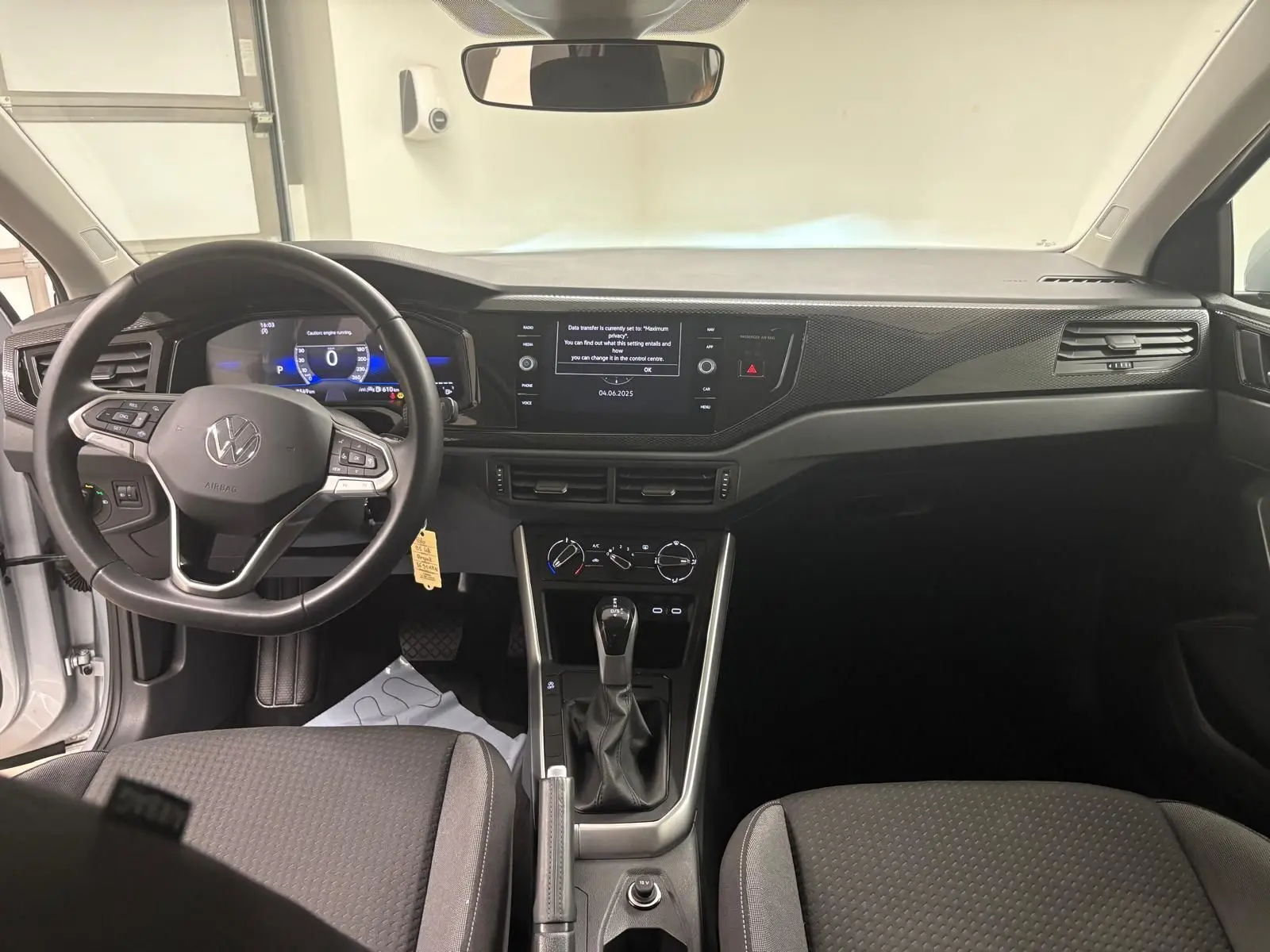 Intérieur de Volkswagen Polo 2024 en Reflet d'argent, vue du poste de conduite avec volant multifonction et écran tactile central.