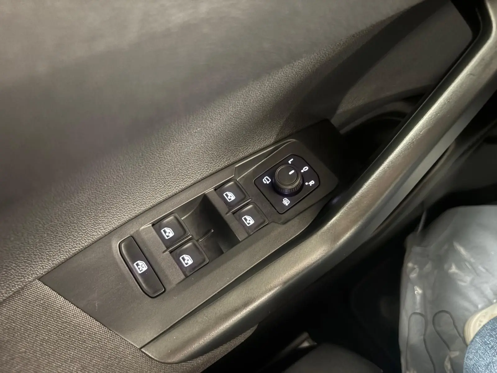 Panneau de commandes des vitres et rétroviseurs côté conducteur d'une Volkswagen Polo 2024 en intérieur noir.