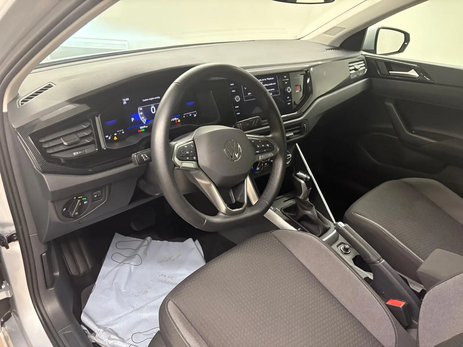 Intérieur avant droit d'une Volkswagen Polo 2024 argent avec tableau de bord numérique et boîte automatique DSG7.