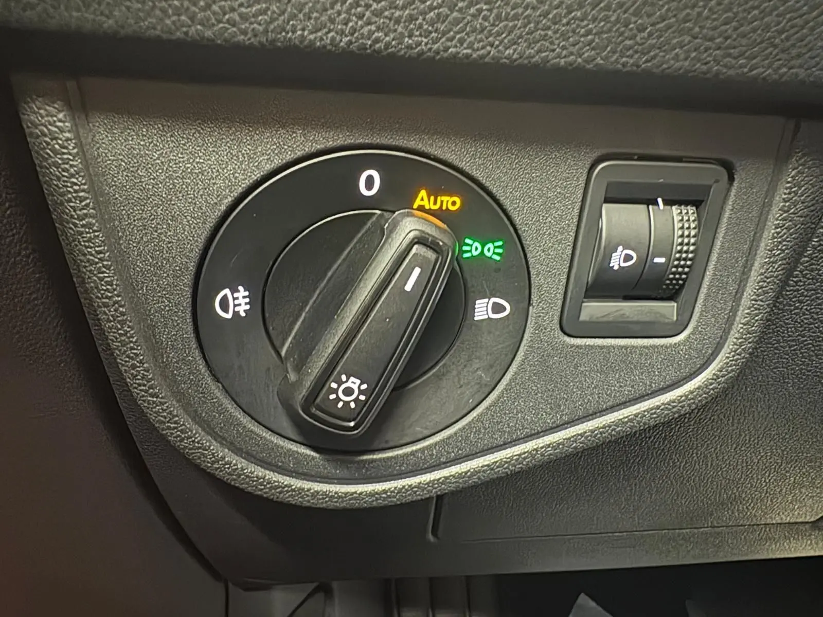 Gros plan sur le sélecteur de phares avec mode automatique activé dans une Volkswagen Polo Reflet d'argent 2024.