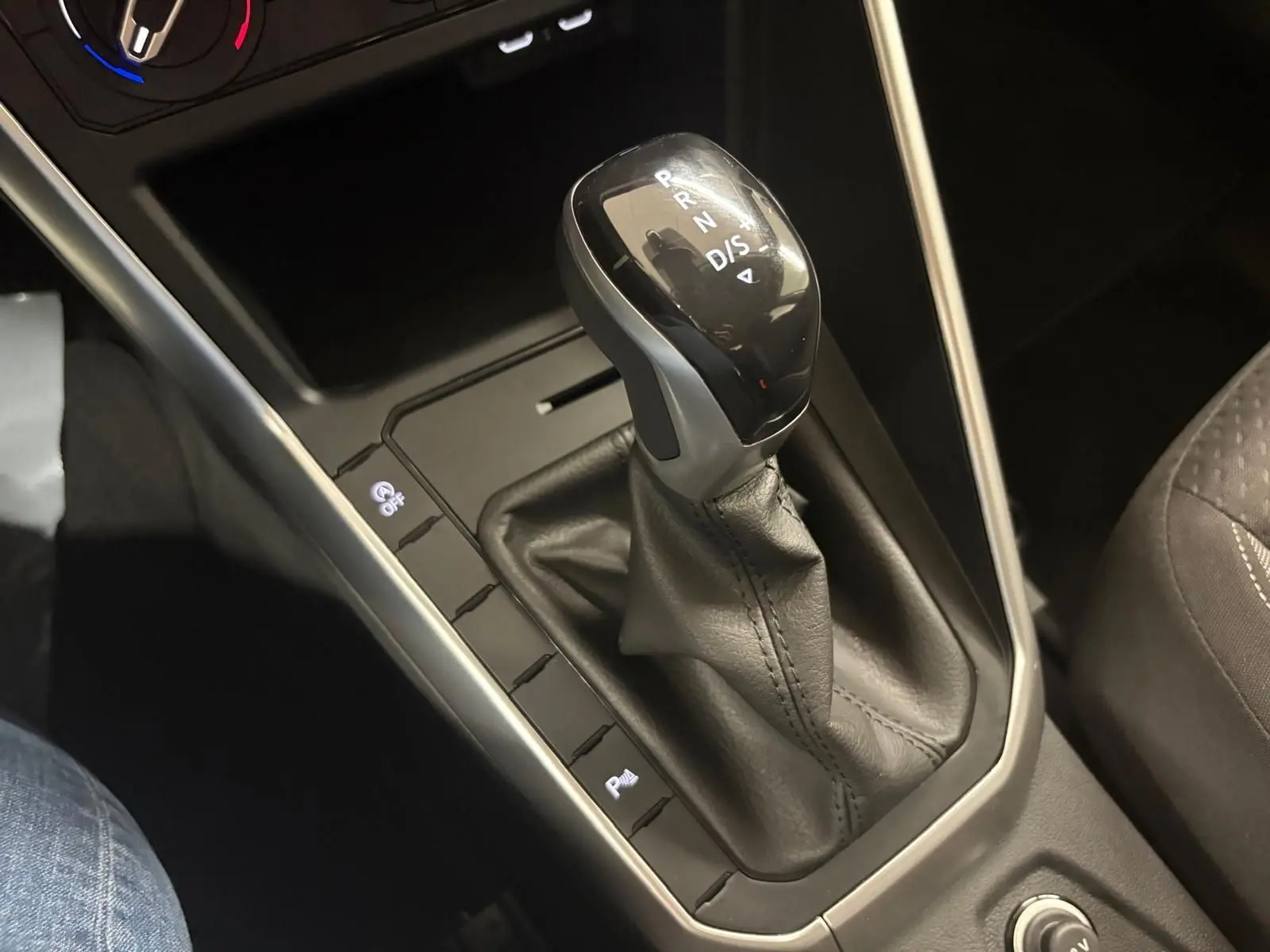 Le levier de vitesse automatique de la Volkswagen Polo 2024 en cuir noir, vue rapprochée de la console centrale.