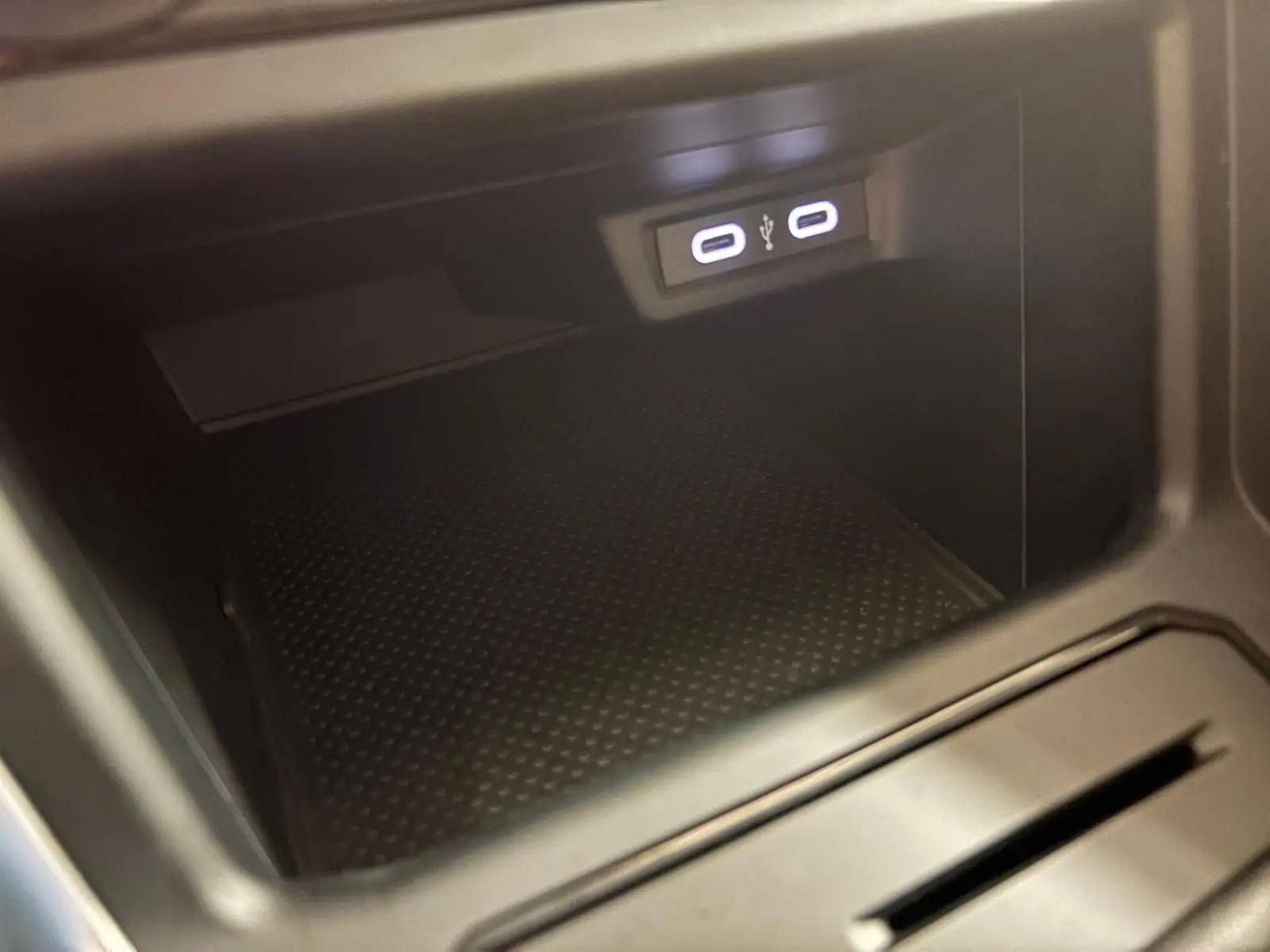 Prise USB double éclairée dans le compartiment de rangement central d'une Volkswagen Polo 2024 couleur Reflet d'argent.