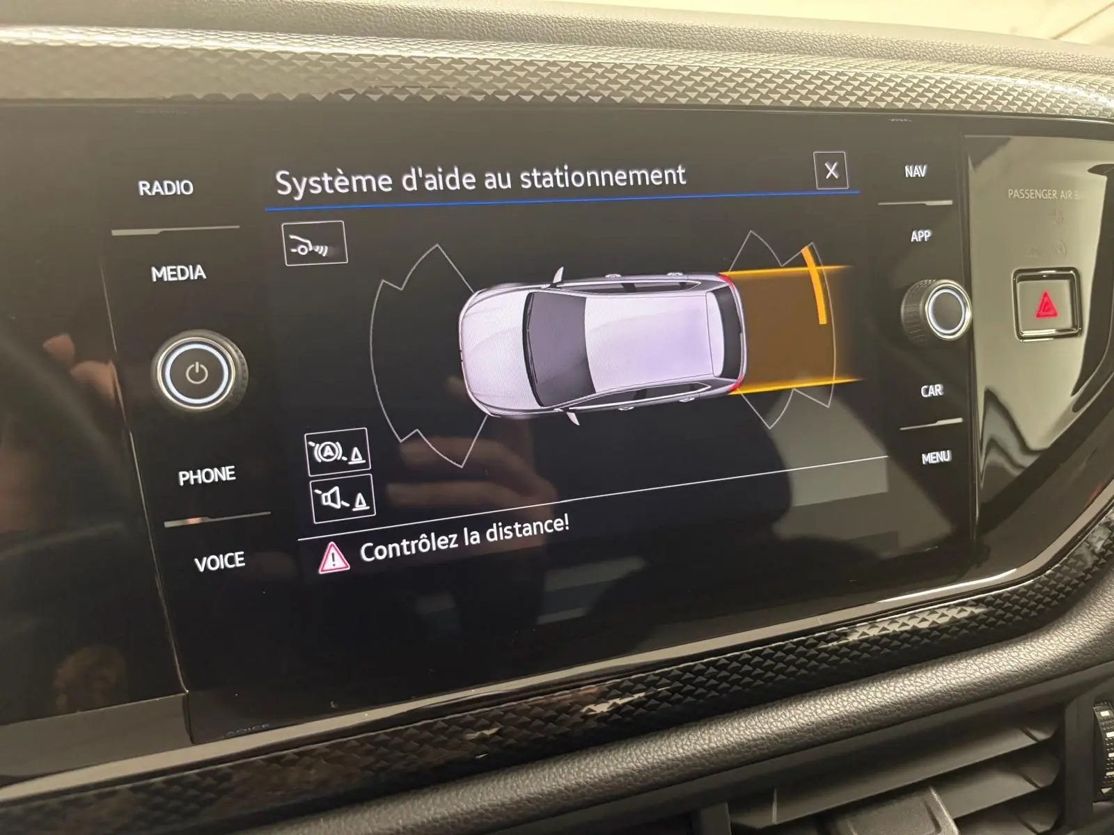 Écran central affichant le système d'aide au stationnement du Volkswagen Polo 2024 en peinture métallisée Reflet d'argent.