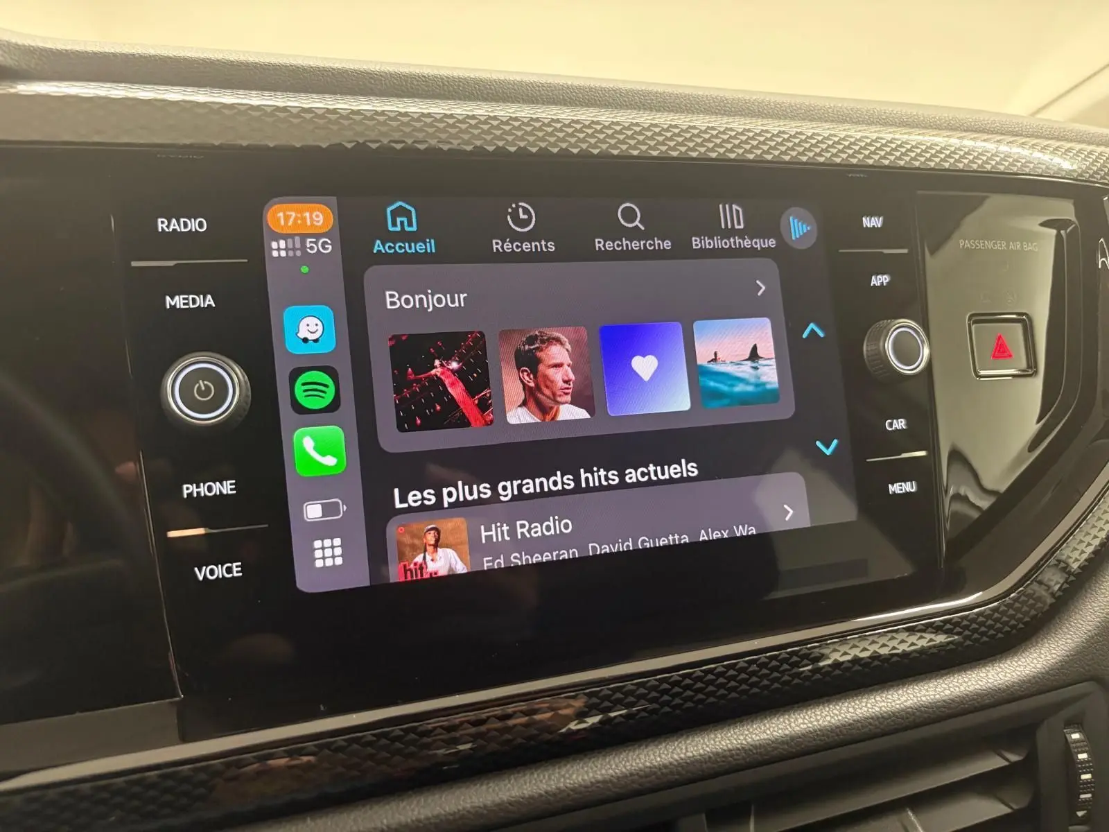 Vue rapprochée de l'écran tactile multimédia intérieur d'une Volkswagen Polo 2024 avec interface connectée et commandes autour.