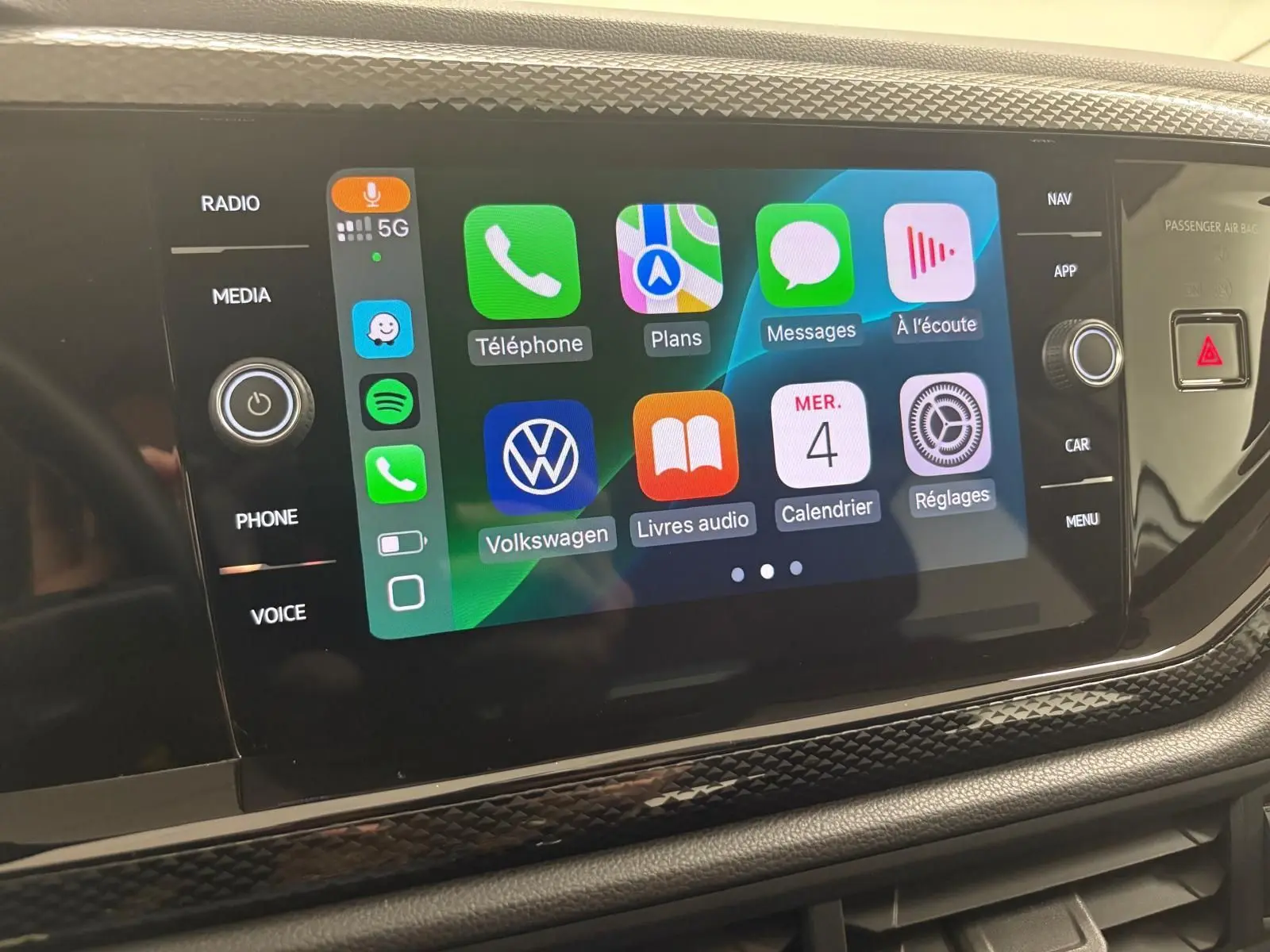 Écran tactile central de la Volkswagen Polo 2024 affichant les applications connectées, avec commandes autour en finition noire.