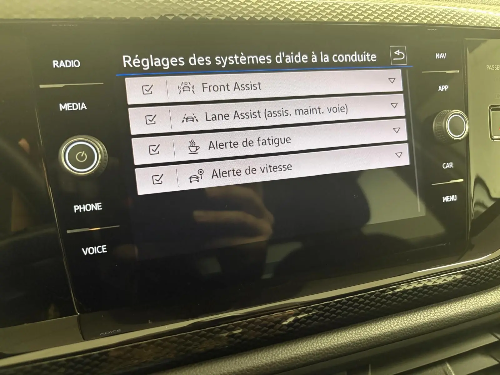 Écran tactile du système d'infodivertissement de la Volkswagen Polo 2024 affichant les réglages d'aides à la conduite.