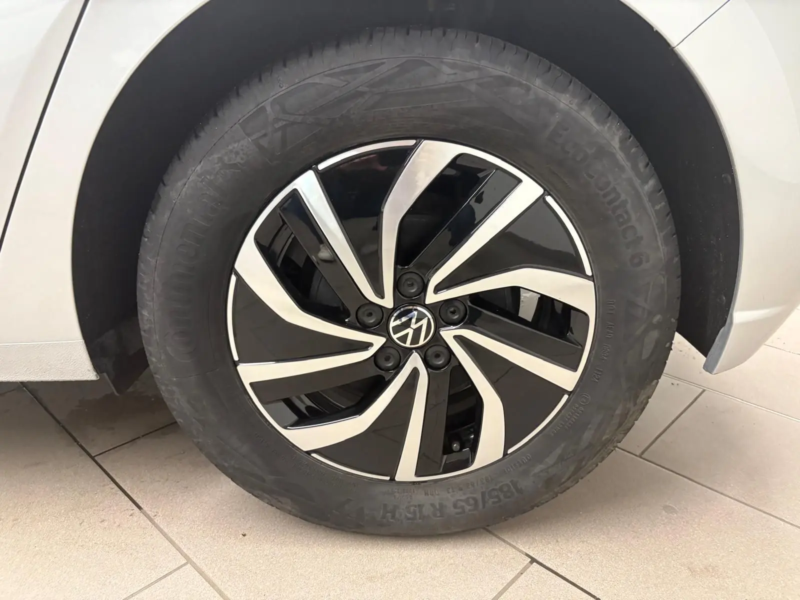 Gros plan sur la roue avant gauche d'une Volkswagen Polo 2024 argentée avec jante alliage bicolore noire et argent.