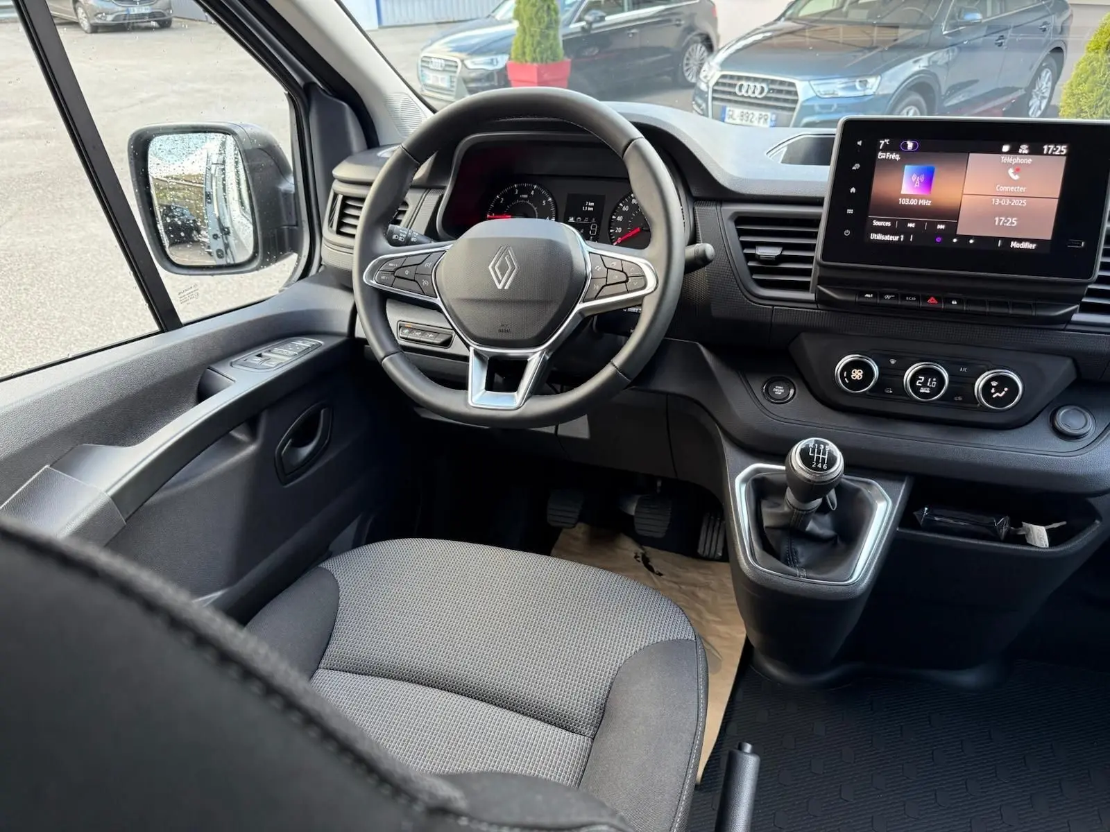 Vue intérieure côté droit du Renault Trafic cabine approfondie 2025 gris Highland, montrant les sièges arrière et avant en tissu bicolore.