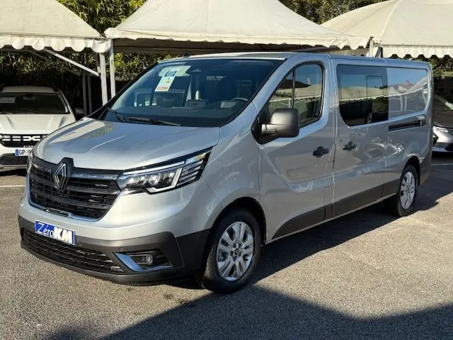 Vue frontale d'un Renault Trafic cabine approfondie gris Highland 2025 avec calandre noire et logo Renault bien visible.