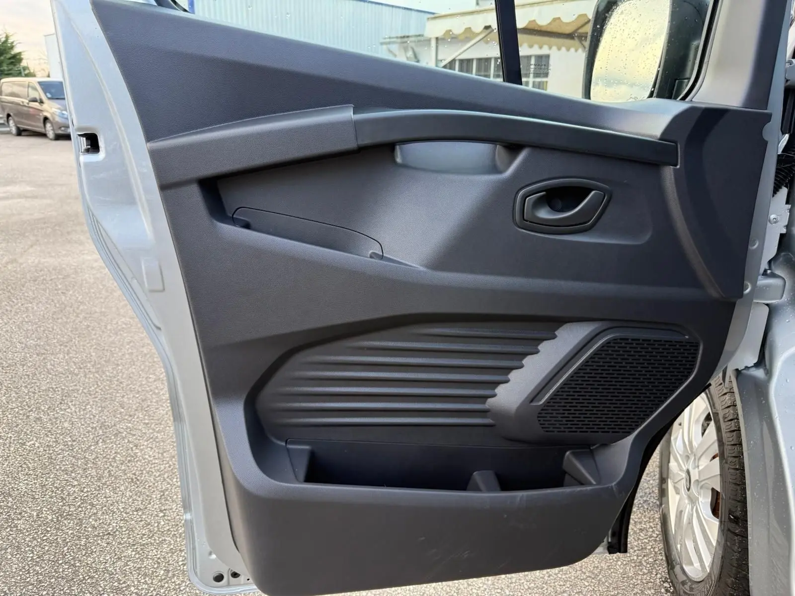 Vue arrière d'un Renault Trafic cabine approfondie gris Highland avec portes battantes et feux arrière verticaux.