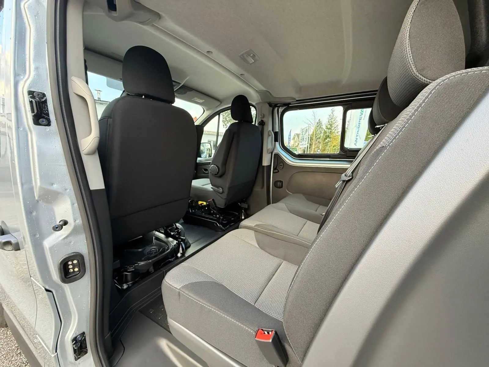 Vue 3/4 avant droit d’un Renault Trafic cabine approfondie gris Highland avec jantes alliage et calandre noire.