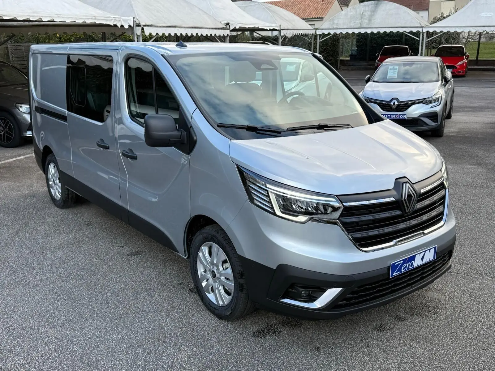 Intérieur Renault Trafic cabine approfondie 2025, vue frontale du poste de conduite avec volant, tableau de bord et levier de vitesses.