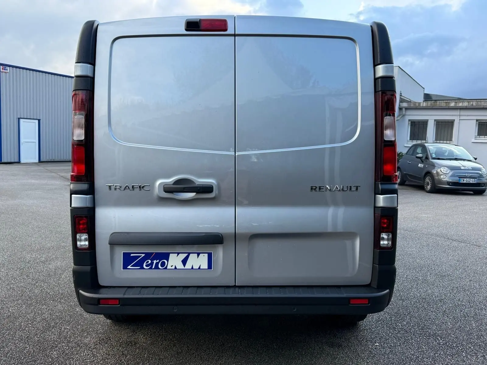 Volant noir avec logo Renault au centre, vue rapprochée de l'intérieur côté conducteur du Trafic cabine approfondie gris Highland 2025.