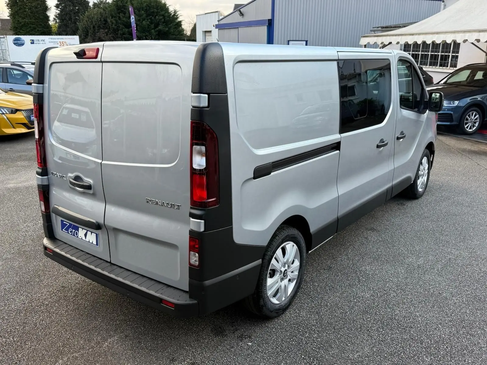 Vue intérieure côté conducteur du Renault Trafic cabine approfondie 2025, sièges gris et volant noir visibles.
