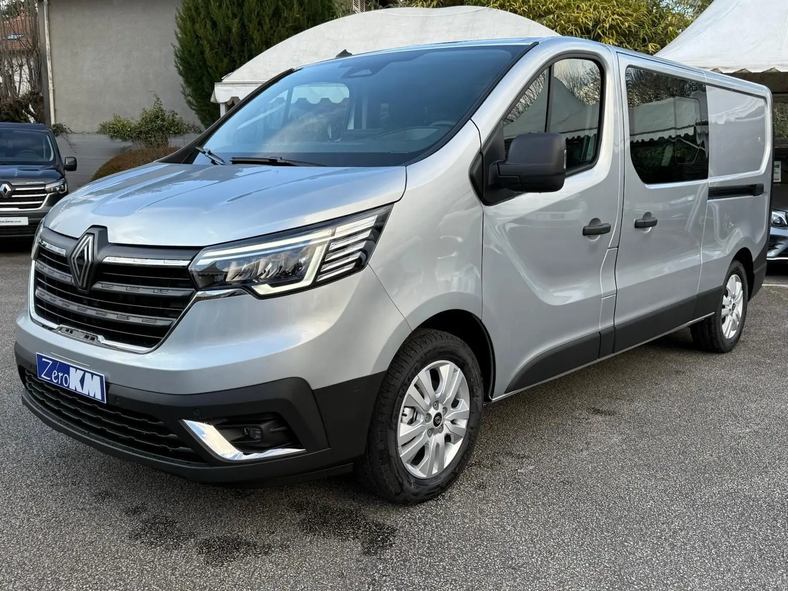 Vue intérieure côté droit des sièges arrière gris d'un Renault Trafic Cabine Approfondie 2025 avec porte coulissante ouverte.