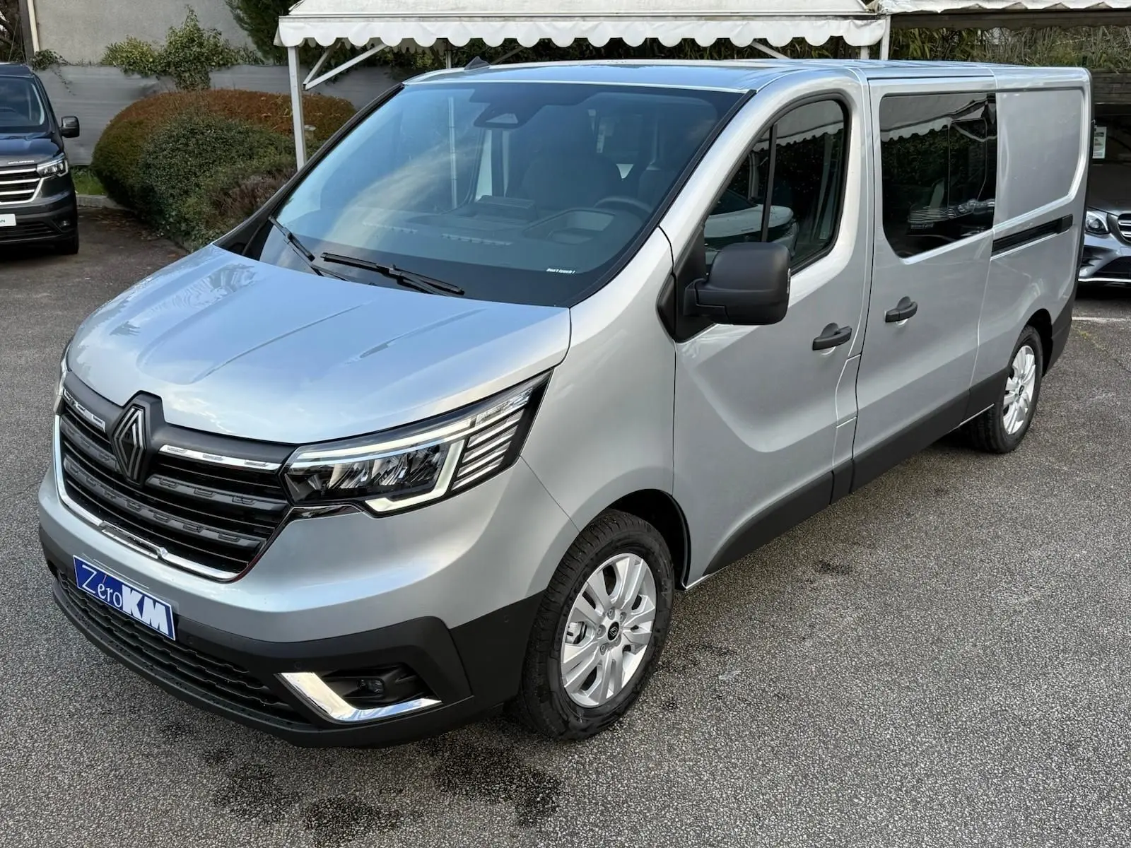 Vue 3/4 avant droite d'un Renault Trafic cabine approfondie gris Highland avec calandre noire et jantes acier.