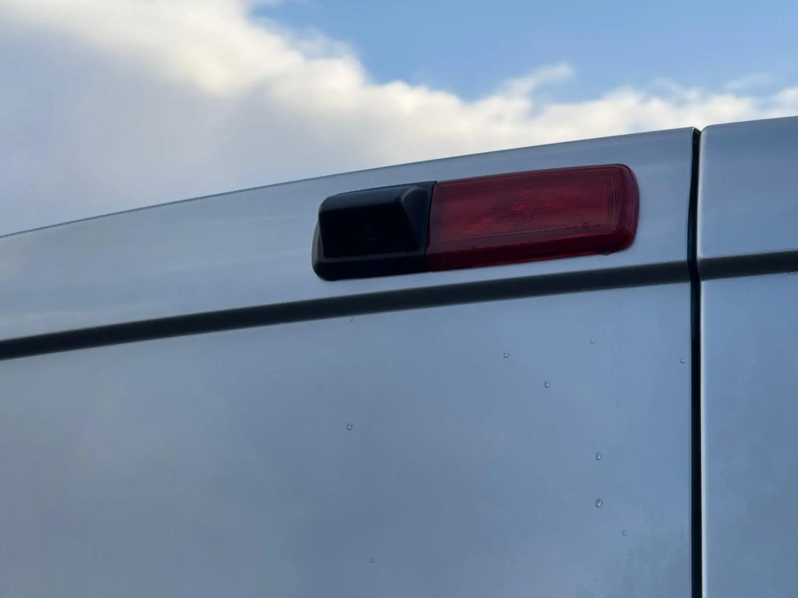 Vue arrière d'un Renault Trafic cabine approfondie gris Highland, portes battantes fermées, éclairage LED vertical visible.