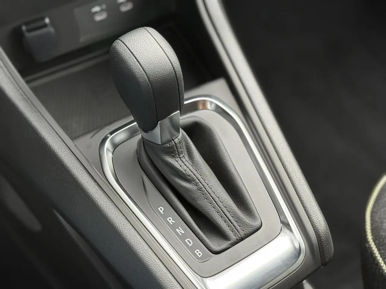 Le levier de vitesses automatique noir en gros plan dans la console centrale du Renault Captur hybride 2025.