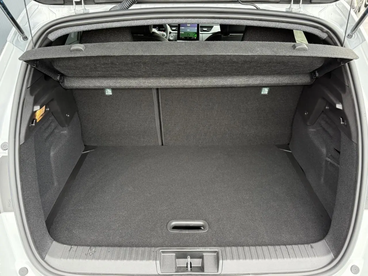 Coffre ouvert vu de l'arrière du Renault Captur blanc nacré, montrant un espace de chargement propre et spacieux.