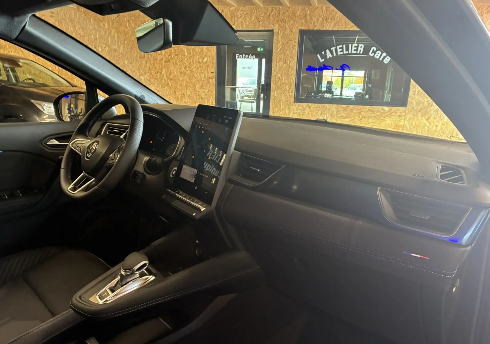 Intérieur du Renault Captur E-Tech 2025 vu côté passager, tableau de bord noir avec écran tactile vertical et finitions Alpine.