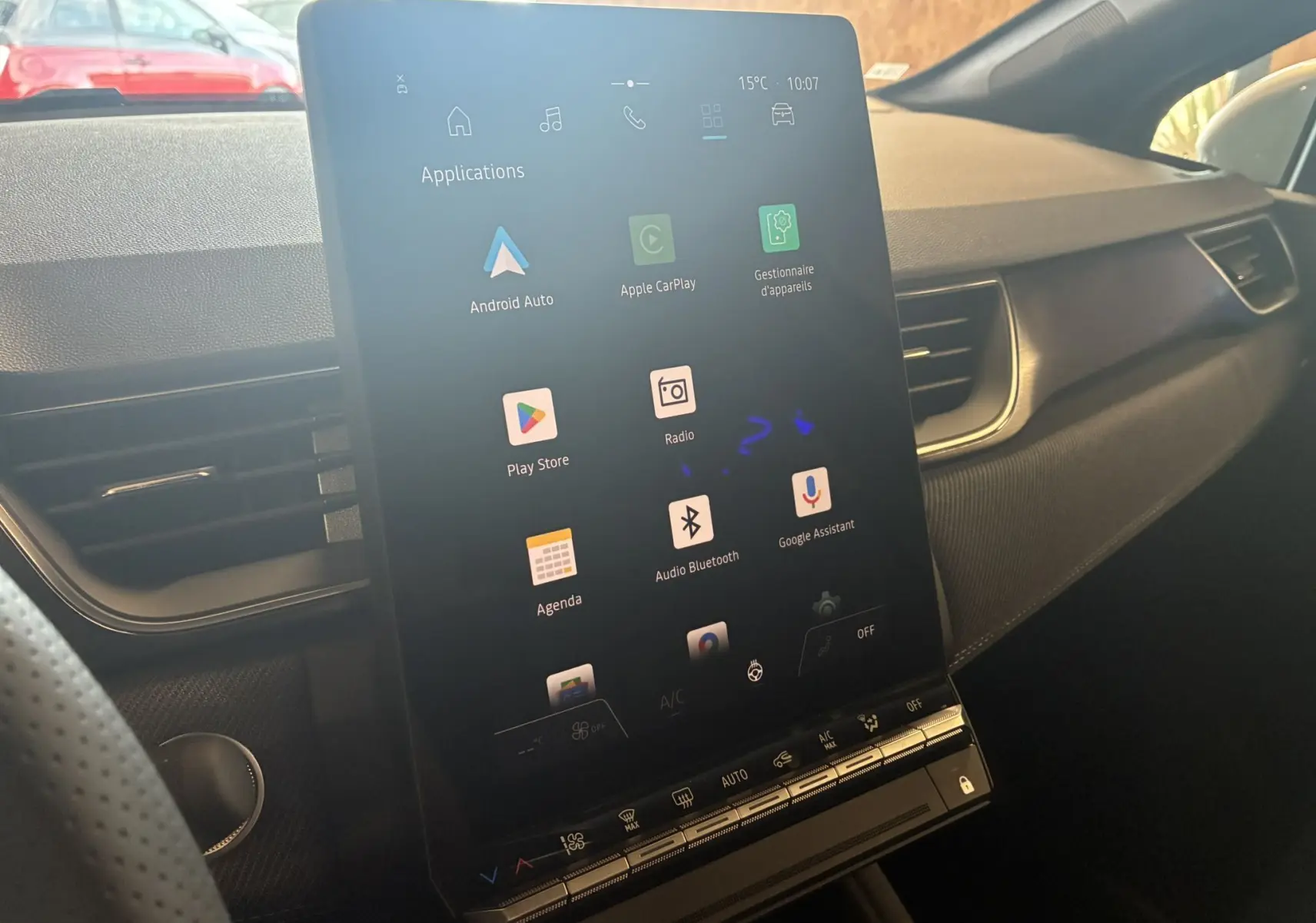 Vue intérieure du tableau de bord du Renault Captur E-Tech 2025, écran tactile vertical avec applications connectées visibles.