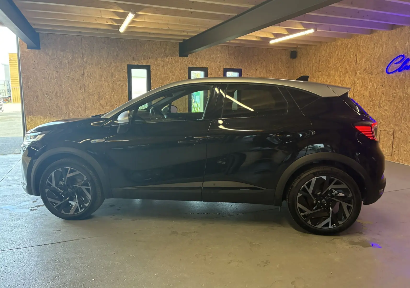 Profil droit du Renault Captur E-Tech Full Hybrid 145ch Esprit Alpine noir étoile avec toit gris en intérieur.